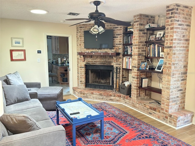 1644 Hibiscus Ave, Winter Park, FL 32789 - living area featuring a textured ceiling, visible vents, wood finished floors, a brick fireplace, and ceiling fan