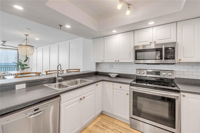 4139 S Atlantic Ave Unit B707, New Smyrna Beach, FL 32169 - kitchen with a sink, appliances with stainless steel finishes, white cabinets, and dark countertops