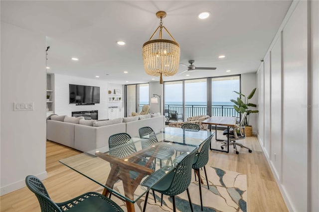 4139 S Atlantic Ave Unit B707, New Smyrna Beach, FL 32169 - dining area with baseboards, ceiling fan with notable chandelier, light wood finished floors, and expansive windows