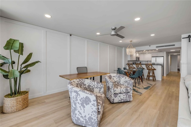 4139 S Atlantic Ave Unit B707, New Smyrna Beach, FL 32169 - living room with light wood-style floors, ceiling fan, a decorative wall, and recessed lighting
