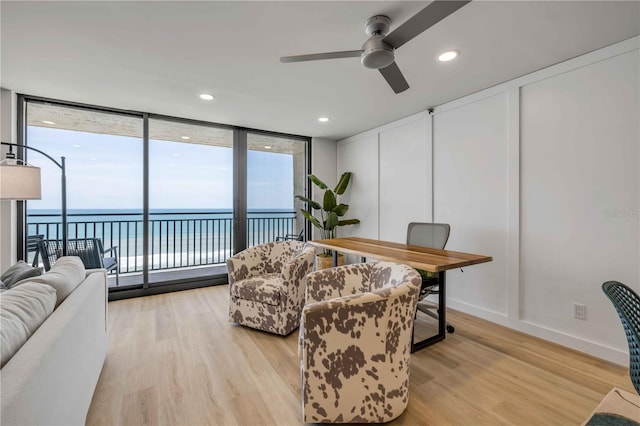 4139 S Atlantic Ave Unit B707, New Smyrna Beach, FL 32169 - living room with a healthy amount of sunlight, ceiling fan, light wood-style floors, and expansive windows