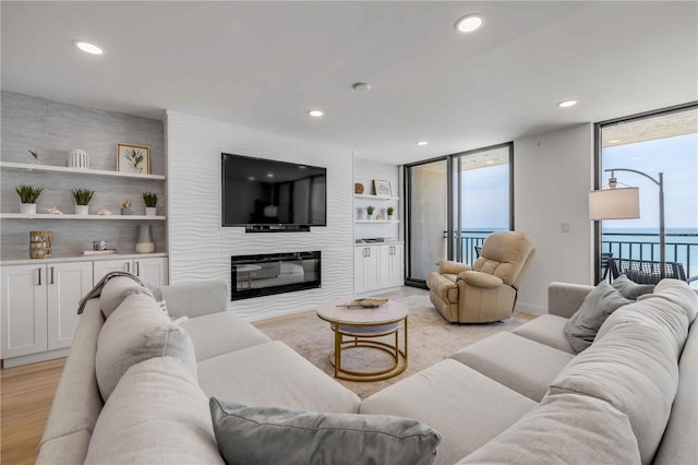 4139 S Atlantic Ave Unit B707, New Smyrna Beach, FL 32169 - living room featuring recessed lighting, built in features, expansive windows, and a large fireplace