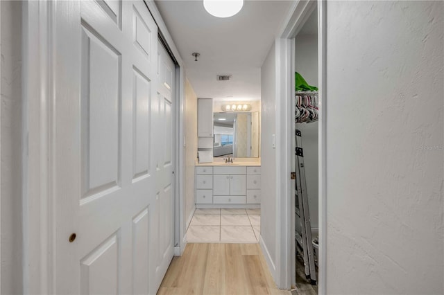 4139 S Atlantic Ave Unit B707, New Smyrna Beach, FL 32169 - hallway with a sink, light wood-style floors, and visible vents