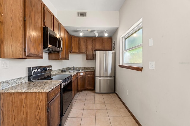 6021 Navajo Way, Orlando, FL 32807 - kitchen with brown cabinetry, light tile patterned floors, appliances with stainless steel finishes, light countertops, and visible vents
