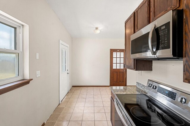 6021 Navajo Way, Orlando, FL 32807 - kitchen with baseboards, light tile patterned floors, stainless steel appliances, and light countertops