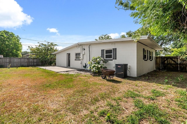 6021 Navajo Way, Orlando, FL 32807 - rear view of house featuring concrete block siding, cooling unit, a patio, a lawn, and a fenced backyard