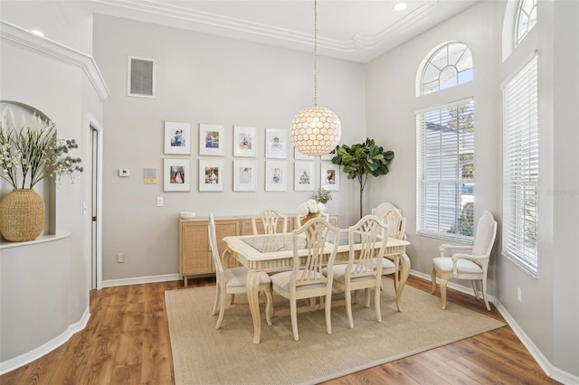 336 Plantation Club Dr, Debary, FL 32713 - dining space with visible vents, a towering ceiling, wood finished floors, and a healthy amount of sunlight