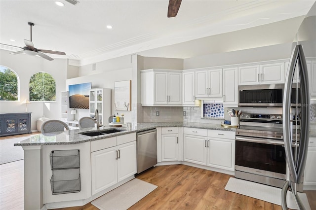 336 Plantation Club Dr, Debary, FL 32713 - kitchen featuring appliances with stainless steel finishes, a sink, a ceiling fan, white cabinetry, and a peninsula