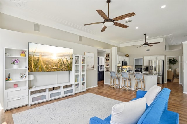336 Plantation Club Dr, Debary, FL 32713 - living room with attic access, a ceiling fan, wood finished floors, visible vents, and ornamental molding