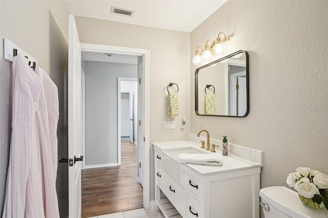 336 Plantation Club Dr, Debary, FL 32713 - bathroom with vanity, toilet, baseboards, wood finished floors, and visible vents