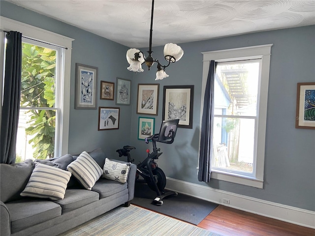 209 E 4th St, Sanford, FL 32771 - interior space featuring baseboards, a notable chandelier, a healthy amount of sunlight, and wood finished floors