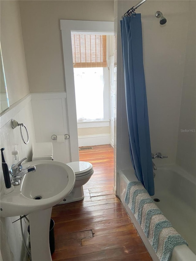209 E 4th St, Sanford, FL 32771 - bathroom with a wainscoted wall, toilet, hardwood / wood-style floors, and shower / tub combo with curtain