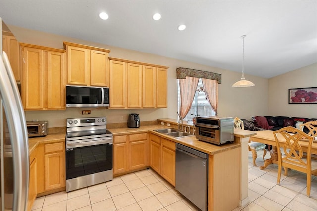 kitchen featuring light countertops, a sink, appliances with stainless steel finishes, and light brown cabinets
