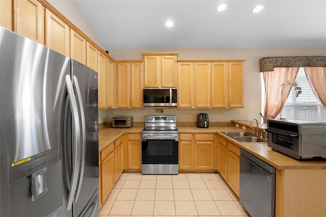 kitchen featuring light brown cabinetry, a sink, appliances with stainless steel finishes, and light countertops