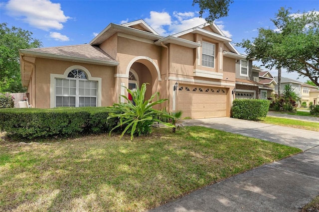 view of front of home with a front lawn, stucco siding, concrete driveway, and an attached garage