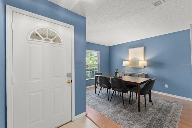 4306 Pebblestone Ct, Orlando, FL 32826 - dining area with baseboards, light wood finished floors, and a textured ceiling