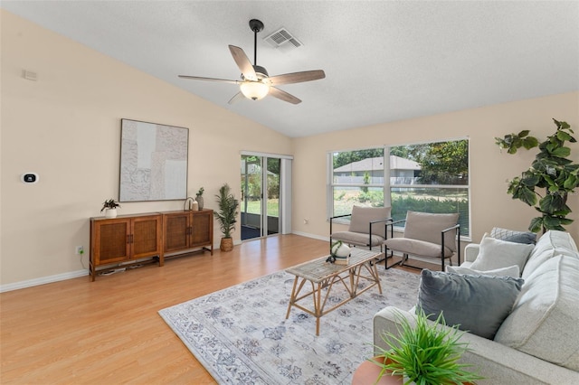 4306 Pebblestone Ct, Orlando, FL 32826 - living room featuring light wood finished floors, a ceiling fan, vaulted ceiling, baseboards, and a textured ceiling