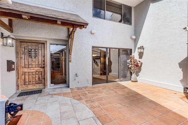 entrance to property with a patio and stucco siding
