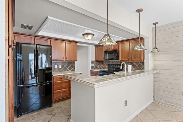 kitchen with light tile patterned floors, black appliances, visible vents, and tasteful backsplash