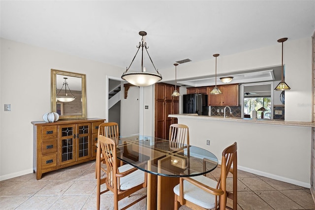 dining room with light tile patterned flooring, visible vents, and baseboards