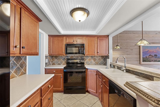 kitchen featuring black appliances, a sink, a raised ceiling, and decorative backsplash