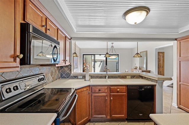 kitchen with black appliances, a sink, a peninsula, and light countertops