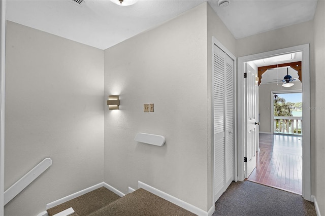 stairway featuring attic access, carpet flooring, and baseboards