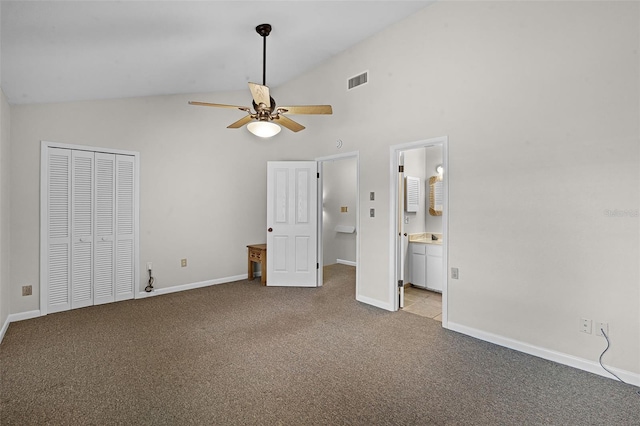 unfurnished bedroom featuring visible vents, a closet, baseboards, carpet floors, and high vaulted ceiling