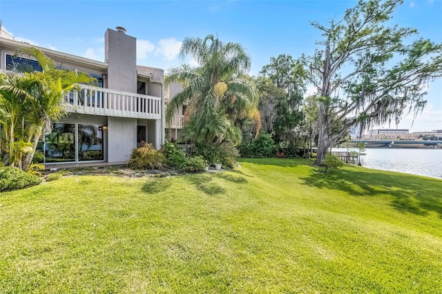 view of yard with a balcony and a water view