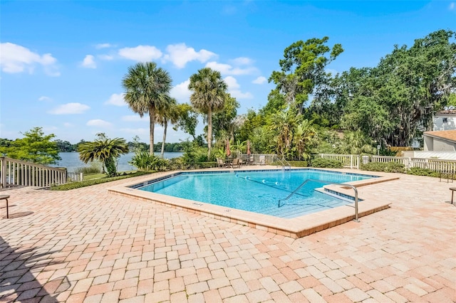 community pool with fence and a patio
