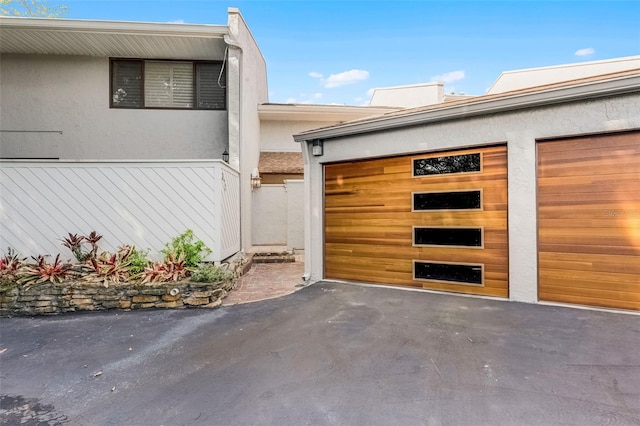 exterior space featuring stucco siding and aphalt driveway