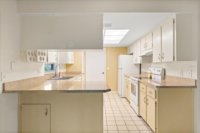 kitchen with a peninsula, a sink, white appliances, under cabinet range hood, and light tile patterned floors