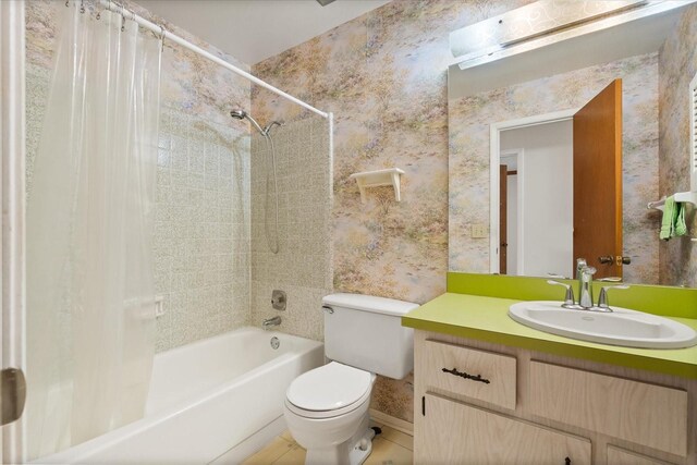 bathroom with wallpapered walls, vanity, baseboards, shower / tub combo, and toilet