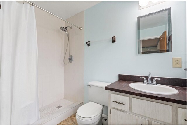 bathroom with vanity, a shower stall, and toilet
