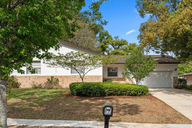 obstructed view of property featuring stucco siding, a garage, and concrete driveway