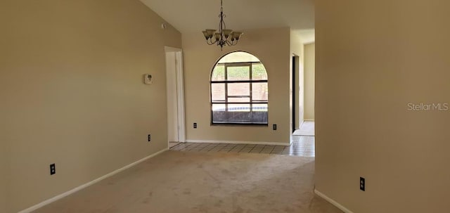 carpeted spare room featuring vaulted ceiling, baseboards, and a notable chandelier