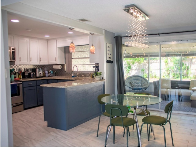 15 Estrella Rd, Debary, FL 32713 - kitchen featuring electric range, a peninsula, white cabinetry, backsplash, and a sink