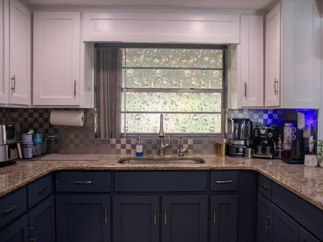 15 Estrella Rd, Debary, FL 32713 - kitchen with backsplash, a sink, white cabinetry, and light stone counters