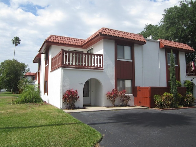 2073 Oak Meadow Cir S, Daytona, FL 32119 - mediterranean / spanish home with a tile roof, a front lawn, a balcony, and stucco siding