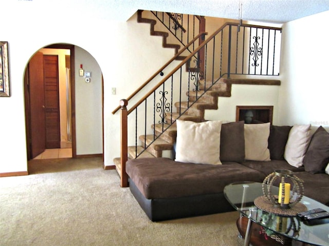 2073 Oak Meadow Cir S, Daytona, FL 32119 - carpeted living room with arched walkways, stairway, and baseboards