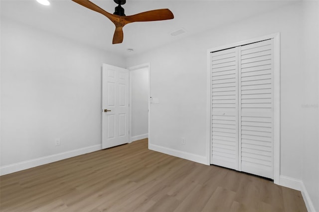 969 Commerce Rd SE, Palm Bay, FL 32909 - unfurnished bedroom with wood finished floors, baseboards, a closet, and ceiling fan