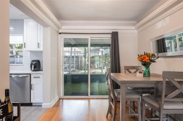 dining area featuring ornamental molding and light wood-style flooring
