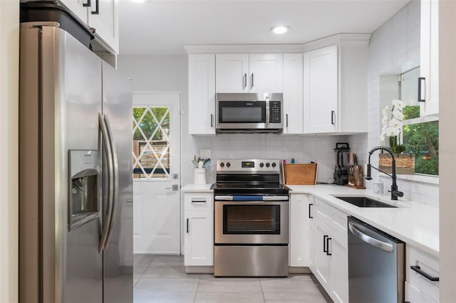 kitchen with light tile patterned floors, appliances with stainless steel finishes, light countertops, and a sink