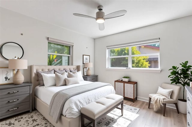 bedroom featuring light wood finished floors, multiple windows, and ceiling fan