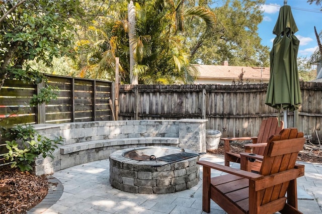 view of patio / terrace featuring an outdoor fire pit and a fenced backyard