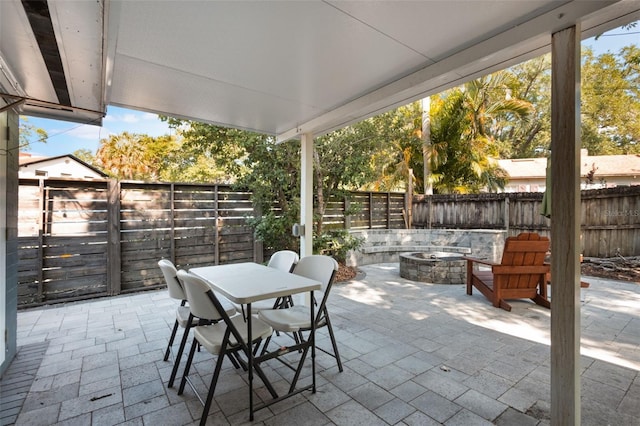 view of patio / terrace with a fire pit, outdoor dining space, and a fenced backyard