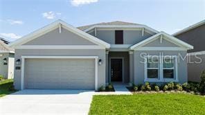 1163 James Paul Rd, Davenport, FL 33837 - view of front of property featuring driveway, an attached garage, and a front lawn