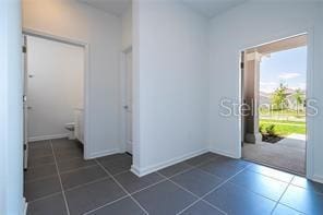 1163 James Paul Rd, Davenport, FL 33837 - foyer entrance featuring dark tile patterned flooring and baseboards