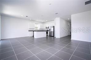 1163 James Paul Rd, Davenport, FL 33837 - unfurnished living room featuring recessed lighting