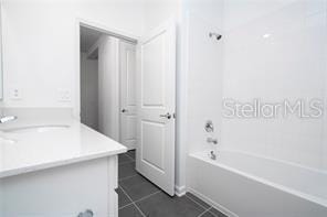 1163 James Paul Rd, Davenport, FL 33837 - bathroom featuring vanity, tile patterned floors, and bathing tub / shower combination